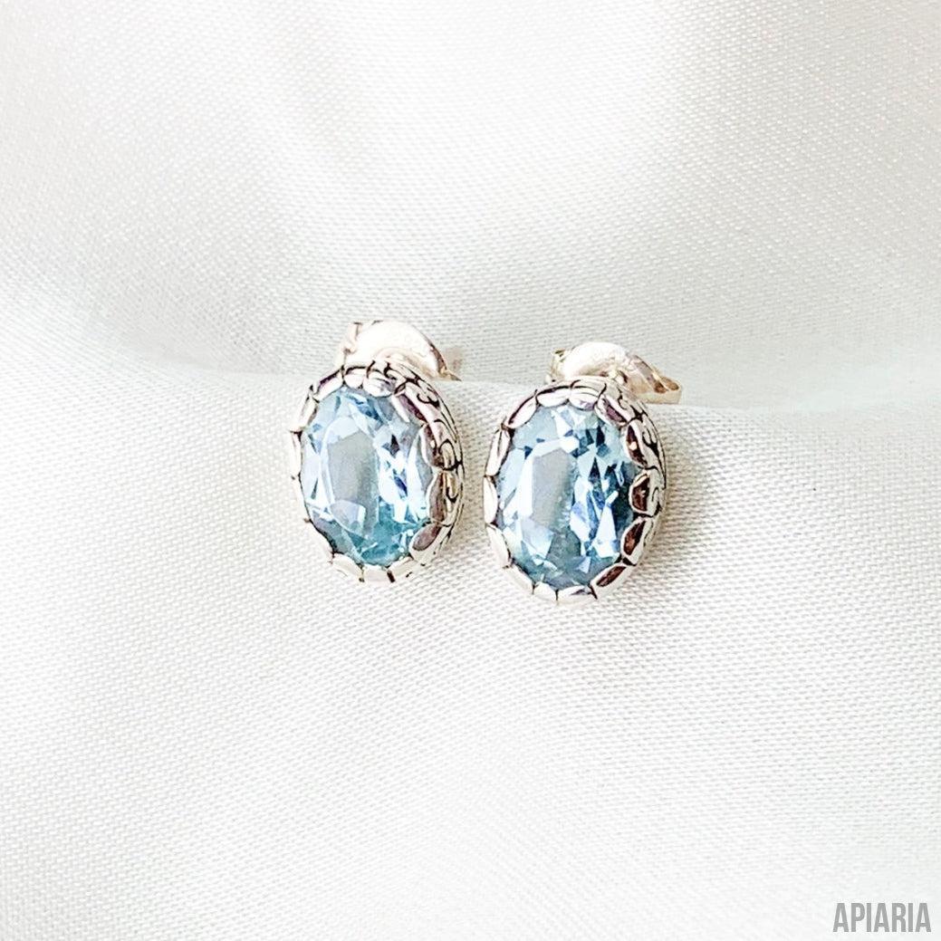Sterling Silver Oval Faceted Blue Topaz Stud Earrings with Intricate Carved Bezels-Jewelry-Apiaria